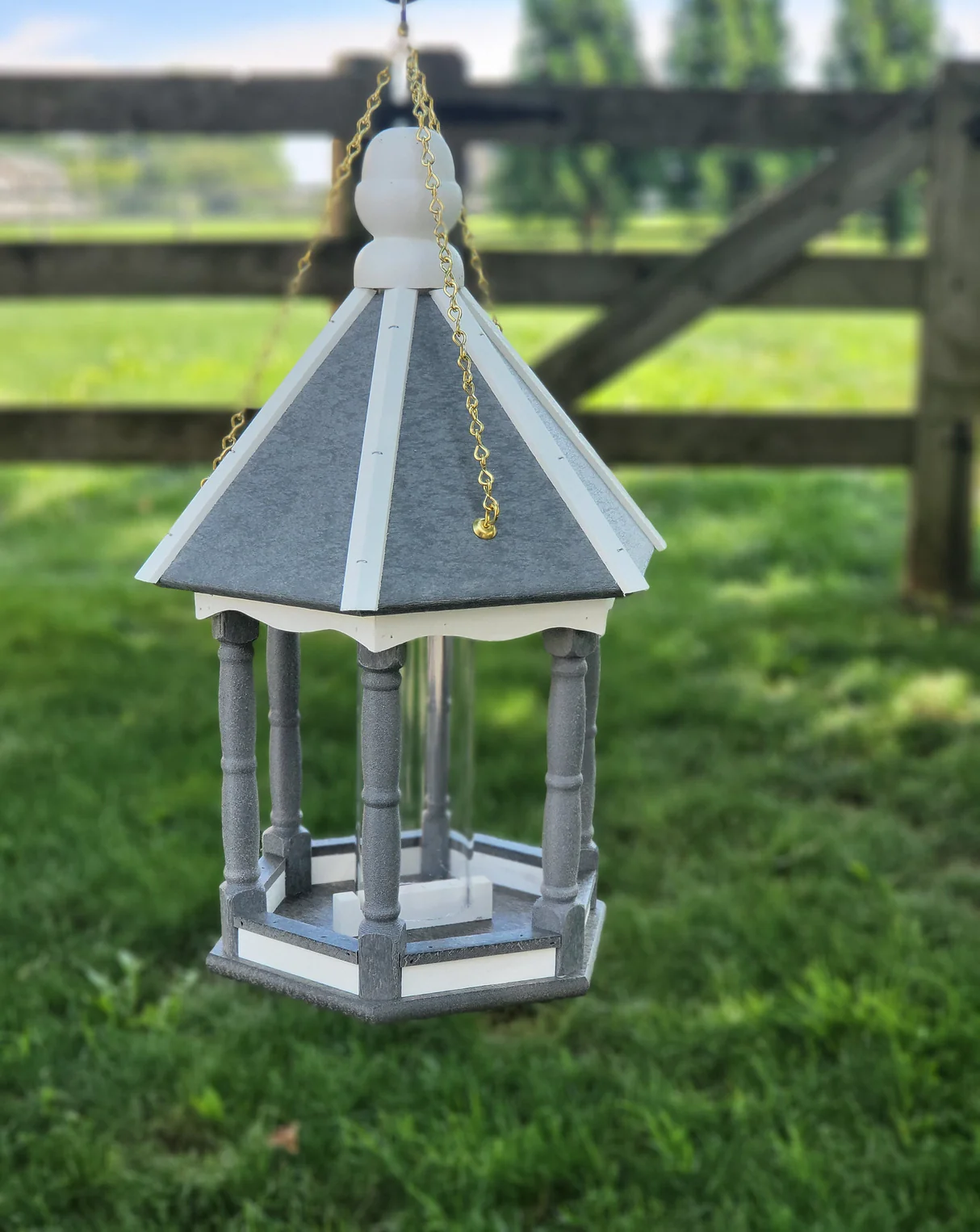 Elegant bird feeder shaped like a gazebo with gray and white details hanging on gold chains